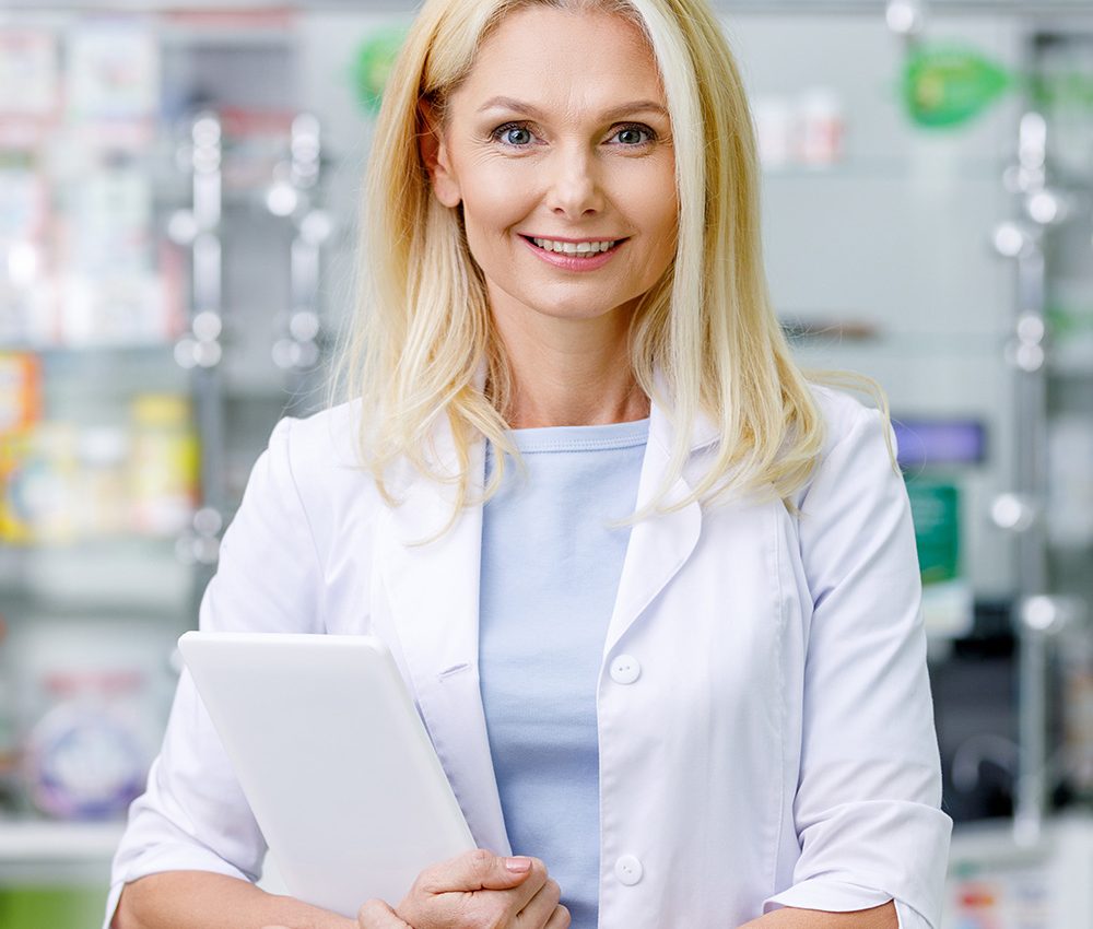 female-pharmacist-in-white-coat-holding-digital-ta-F5GU928.jpg